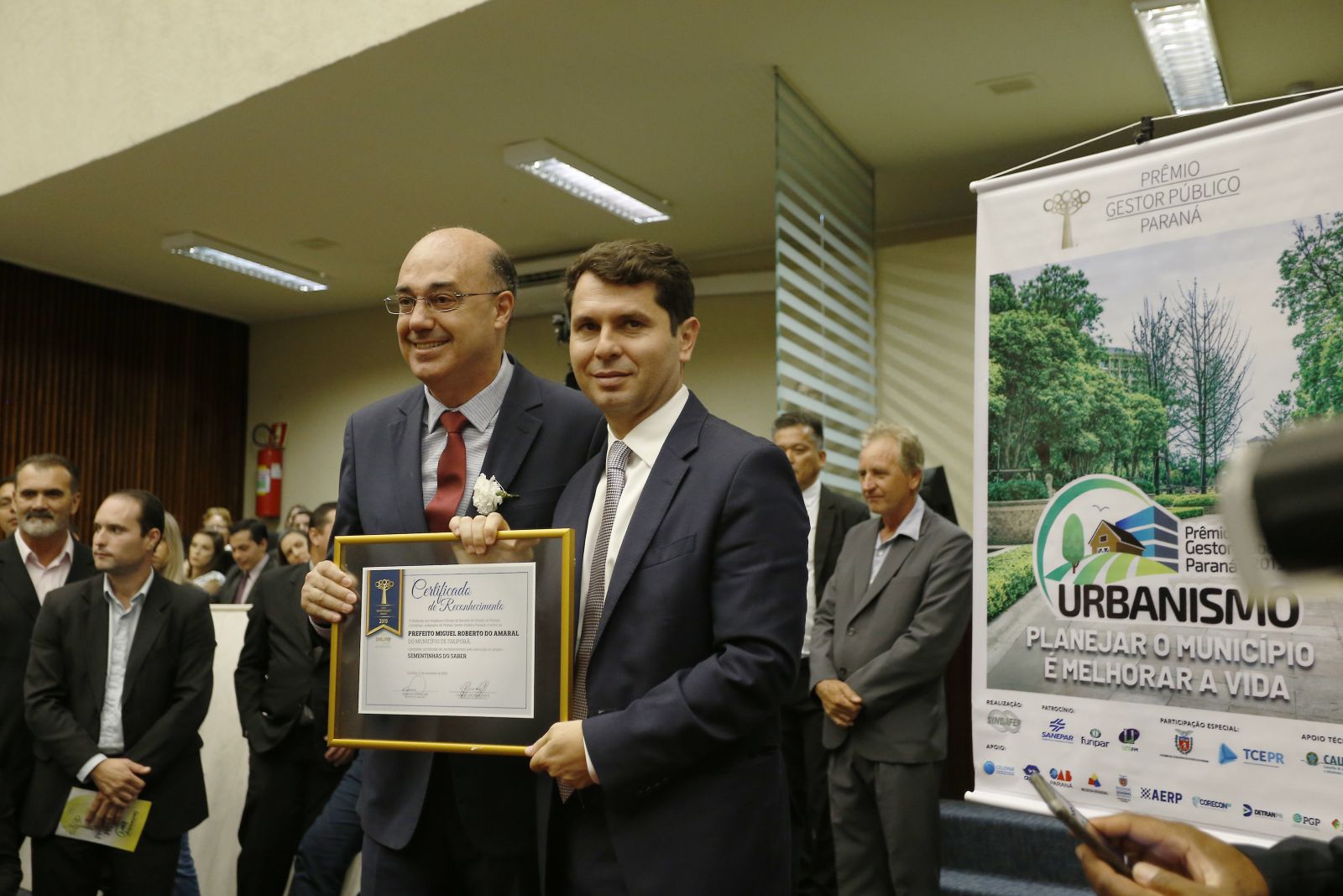 Na 7ª edição, o Prefeito de Ivaiporã, Miguel Roberto do Amaral, recebe o Certificado de Reconhecimento pelo projeto Sementinhas do Saber.